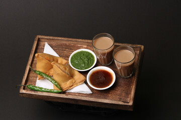 Indian snack Homemade spicy and delicious samosa served with green, tamarind chutney cutting masala...