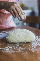 Hands of a woman making dough on a wooden table in Turkey