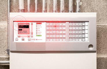 Fire alarm system with active alert and peeping. Control panel display with smoke alarm message and flashing red lights. Fire control panel in electrical room of residential and commercial building.