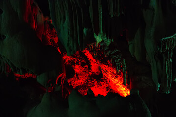 It is an underground cave with stalactites and stalagmites and a glowing crater. Dark and gloomy dungeon