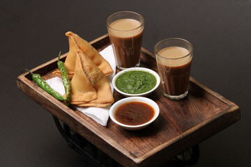 Indian snack Homemade spicy and delicious samosa served with green, tamarind chutney cutting masala...