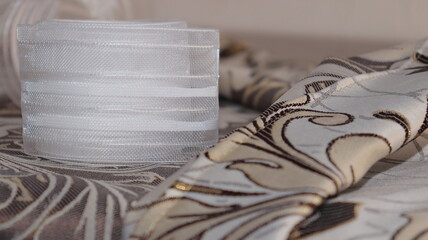 Tape and fabric for curtains close-up. Technological process of sewing curtains.