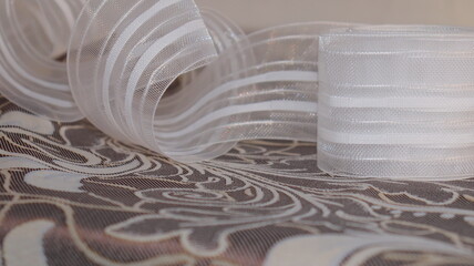 Tape and fabric for curtains close-up. Technological process of sewing curtains.