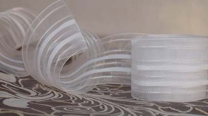 Tape and fabric for curtains close-up. Technological process of sewing curtains.