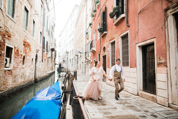 Fototapeta na wymiar Wedding couple holding hands, groom and bride together on wedding day in Venice, Italy