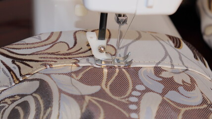 process of sewing curtains on the sewing machine. Sewing foot and needle close-up.
