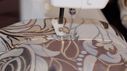 process of sewing curtains on the sewing machine. Sewing foot and needle close-up.