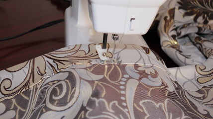 process of sewing curtains on the sewing machine. Sewing foot and needle close-up.
