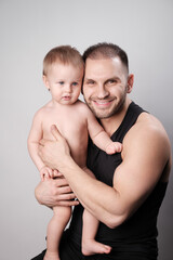 Portrait of a father and son in the studio on a gray background..