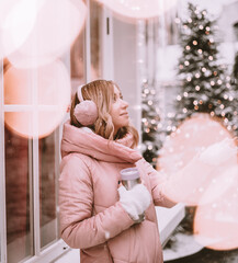 beautiful girl in the winter outdoors rejoices in the snow