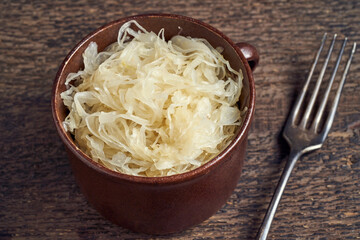 Fermented white cabbage in a pot on a table