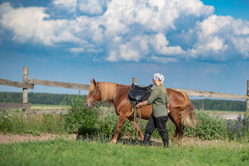 Young beautiful girl at the farm stable with a horse.
