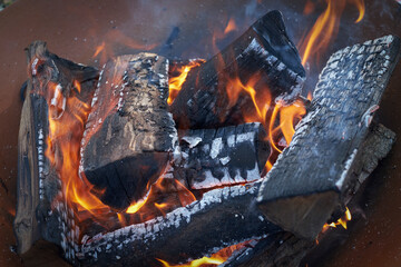 close up of a bonfire with already charred wood and flames