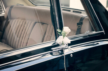 detalle de coche clásico de lujo con decoración floral de bodas.