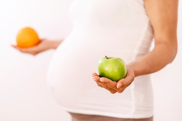 Pregnant woman holding fruits in her hands