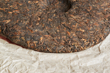 Naklejka premium Chinese pressed pu er tea on wrapping paper close-up
