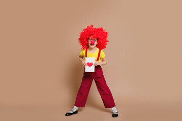 Happy Valentine's Day. Bright red Cupid on Valentine's day. Let's celebrate. Funny baby clown playing at home. April 1 concept of April fool's Day. Selective focus.