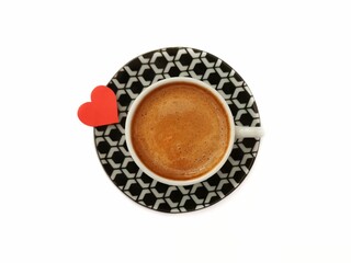 Turkish coffee. Black and white patterned cup. Red heart next to coffee. White background. February 14 Valentine's Day.