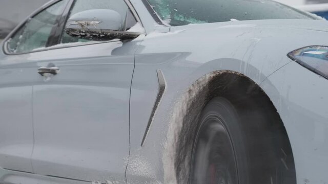 Extreme close up spinning wheel of car hit the road drifting on snow. Car drift on parking lot or road.