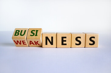 Business or weakness symbol. Turned wooden cubes and changed the word 'weakness' to 'business'. Beautiful white background, copy space. Business or weakness concept.