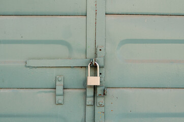 Padlock on an iron door. Iron fence. Steel door with a lock.