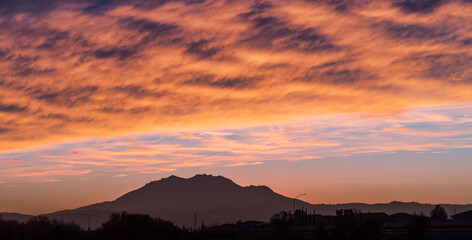 Colorful sunset in East San Francisco Bay Area, with brightly colored clouds covering the sky, and Mt Diablo visible on the horizon; Contra Costa County, California