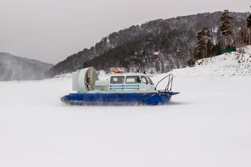 Emergency hovercraft on snowy surface lake in Siberia, Russia. Motion blur