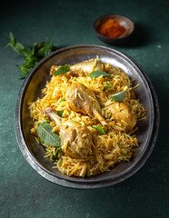 Indian or Pakistani food. Chiken Biryani rice biriany with mint herb and naan bread on green background