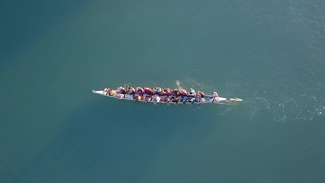 Dragon Boat team rowing together. Teamwork on Dragon Boat at sea. 