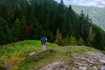 female hiker with a backpack on a mountain with trees