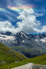 Obraz premium Iridescent cloud over the road to Stelvio pass (Lombardy) at summer