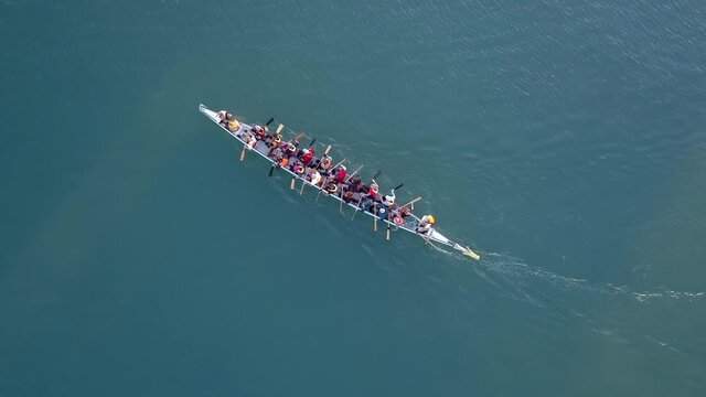 Dragon Boat team rowing together. Teamwork on Dragon Boat at sea. 