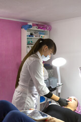 The girl makes injections to increase the volume of the lips