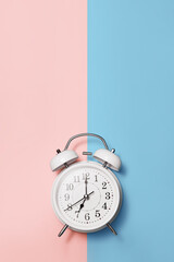 White clock alarm clock in vintage style on color background vertical shot with copy space