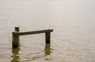 Old vintage wooden piles in the water. Background. 