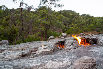 Flames from underground on Mount Chimaera in Turkey. Burning volcanic gas on rock surface. Ancient...