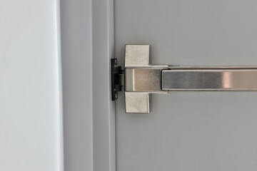 Emergency fire exit door. Closed up latch and rusty door handle of emergency exit. Push bar and...