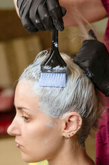 Young beautiful woman dyes her hair at home during quarantine. Home hair care