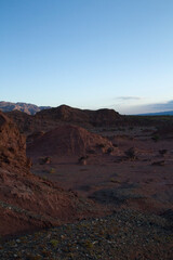 The red canyon and rocky valley at sunset. Panorama view of the arid desert, sandstone formations, and hills in Talampaya national park in La Rioja, Argentina.