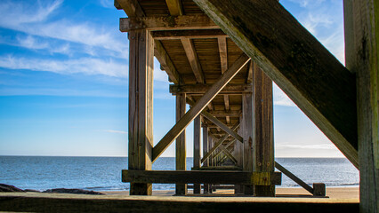 Vendee, France; January 15, 2021: Structure of the pier at Bois de la Chaize beach, on Noirmoutier island, on a clear day.

