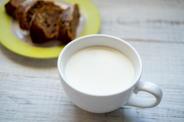 Milk in a cup. Morning breakfast with a muffin.