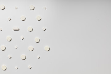 White pills on white background pattern