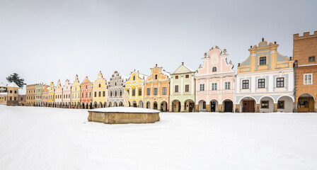 Obraz premium Main square of Telc with its famous 16th-century colorful houses, a UNESCO World Heritage Site since 1992, on a winter day with falling snow.