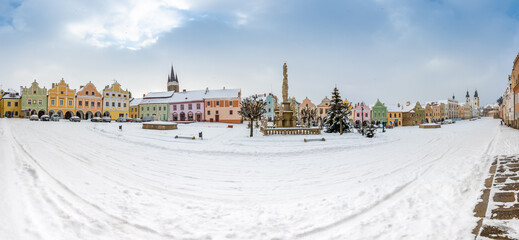 Main square of Telc with its famous 16th-century colorful houses, a UNESCO World Heritage Site since 1992, on a winter day with falling snow.