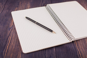 notebook with pen on a wooden table
