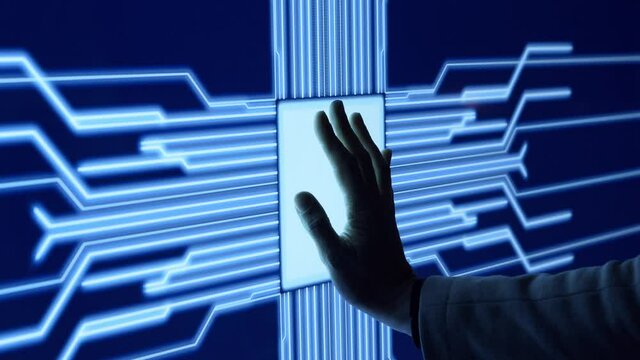 Human arm is pressing a digital button on a glowing touchscreen. Futuristic microprocessor is starting the operation of the computer program. Machine learning and artificial intelligence.