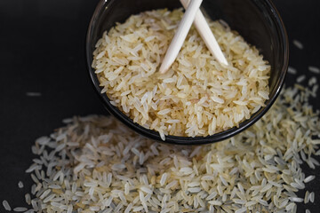 Arroz integral en un recipiente de vidrio con palillos chinos