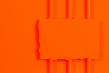 Blank ripped piece of paper, torn paper card on orange color geometric background. Top view