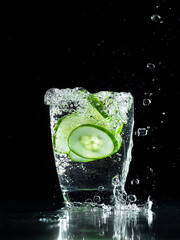 Fototapeta na wymiar Fresh cucumber water drink in dark background