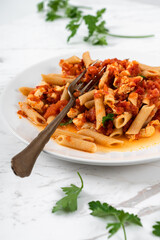 Pasta Penne, Tomato Sauce and Salmon on White Marble Table Background